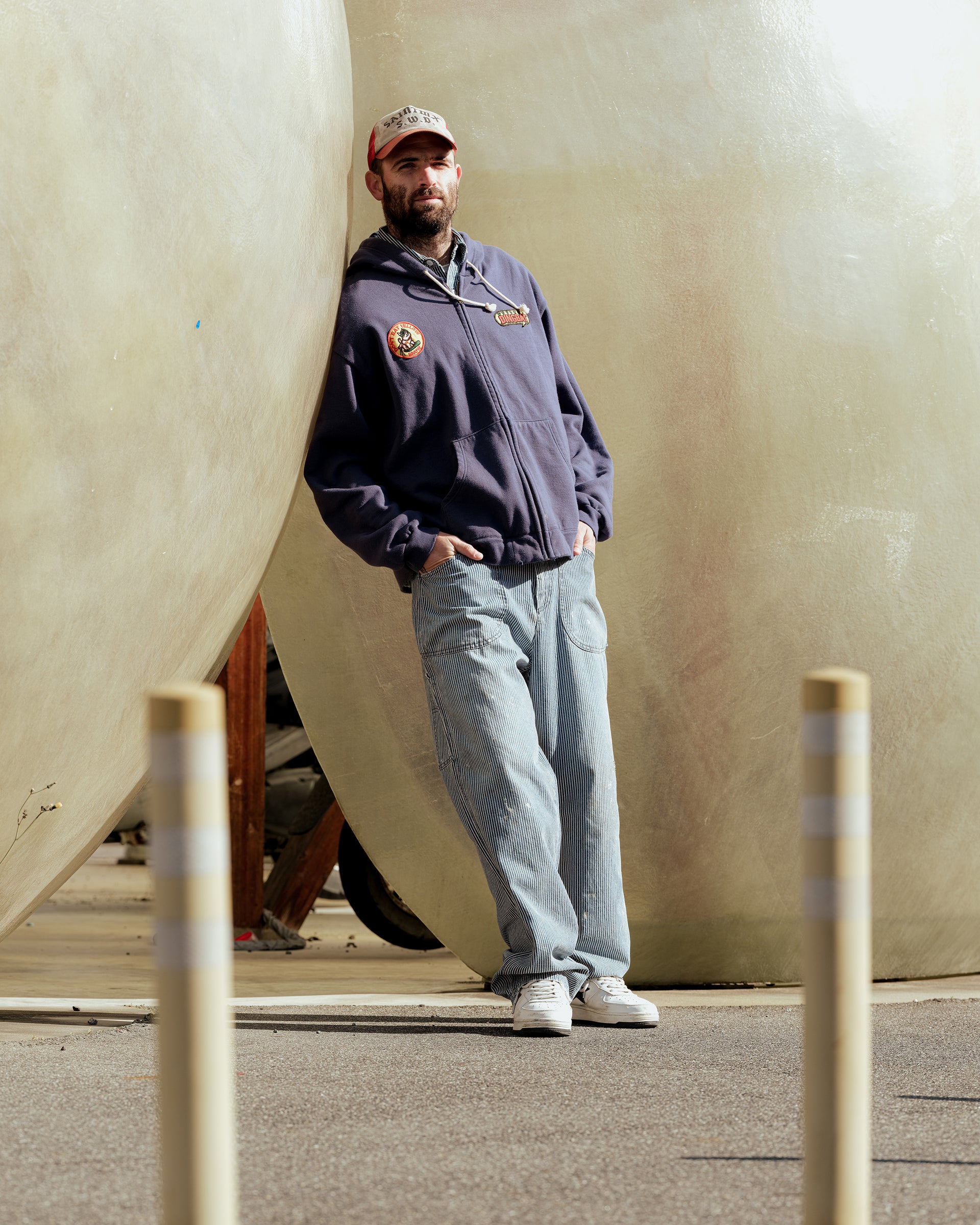 SWJP Zip Hoodie - Sean Wotherspoon Designs 公式。ネイビーフーディーを着用した男性、カジュアルなデニムパンツとコーディネート。